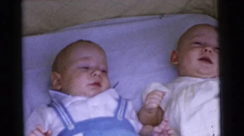 1961: two happy infants in bassinet responding to adult attention DETROIT Stock Footage