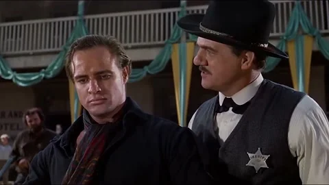 1961 - In this western, the sheriff rips the back of a man's shirt open. When he Stock Footage 238543777