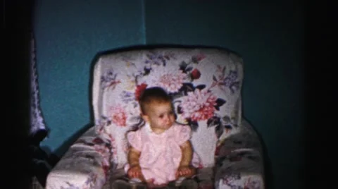 1962: baby sitting on couch relaxing like shes adult HAGERSTOWN, MARYLAND Stock Footage