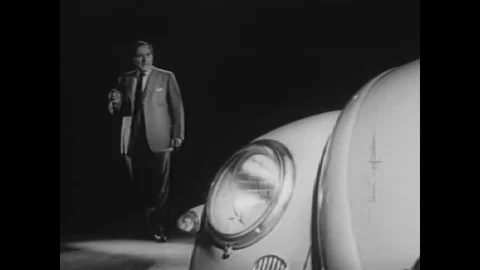 1962 - A car designer studies a Volkswagen Beetle and suggests enlarging the Stock Footage