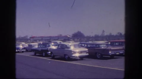 1962: monorail nearby a parking lot with the train speeding off Stock Footage