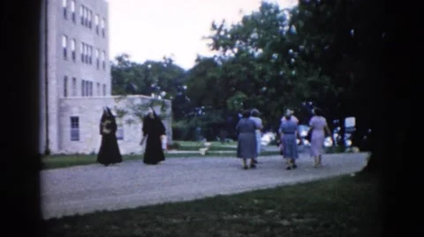 1962: nuns and other people walking down a sidewalk outdoors CHICAGOLAND AREA Stock Footage