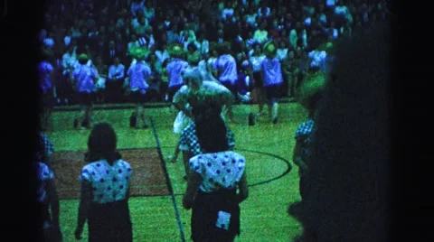 1962: people dancing and giving a show on a basketball court with spectators Stock Footage