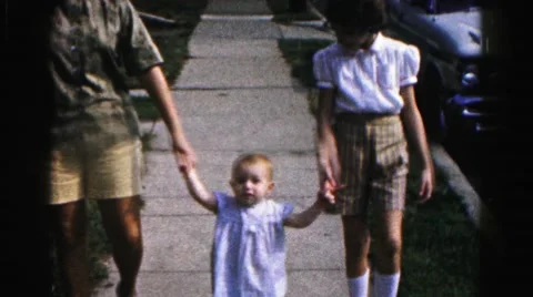 1962: people teaching child how to walk down the sidewalk HAGERSTOWN, MARYLAND Stock Footage