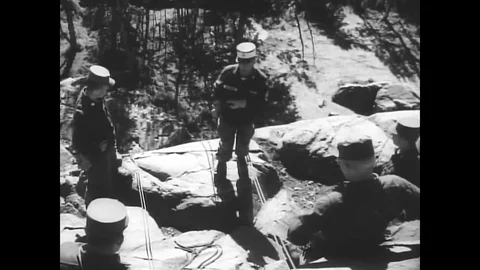1962 - Student soldiers learn body repelling on a cliff during their training in Stock Footage