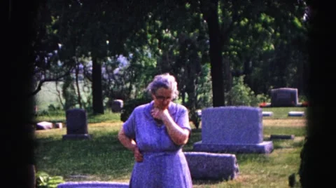 1962: a woman standing alone in a cemetery looking down at a grave HAGERSTOWN Stock Footage