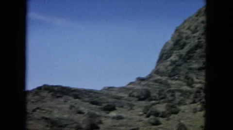 1964: a hilly area is seen with trees and greenery and water beside HAWAII Stock Footage