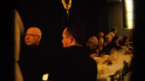 1964: a woman carrying a cake walks past a table of men in tuxedos. RACINE Stock Footage