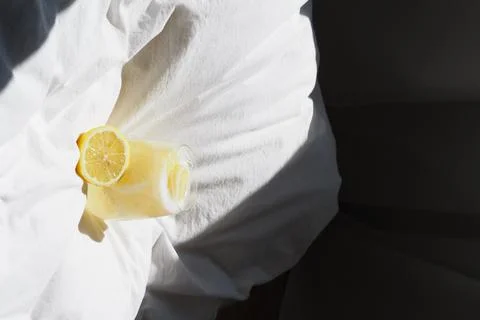 A closeup of a lemon juice with lemons on the bed xkwx bed, closeup, lemon, juice, fruit, glass, fresh, food, drink, citrus, cocktail, healthy, yellow, background, sweet, summer, slice, beverage, white, cold, tropical, vitamin, organic, diet