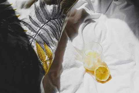 A closeup of a lemon juice with lemons on the bed xkwx bed, closeup, lemon, juice, fruit, glass, fresh, food, drink, citrus, cocktail, healthy, yellow, background, sweet, summer, slice, beverage, white, cold, tropical, vitamin, organic, diet