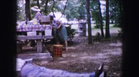 1964:DALLAS TEXAS.Woman Wearing Green Skirt Stands Near Red Checked Picnic Stock Photos