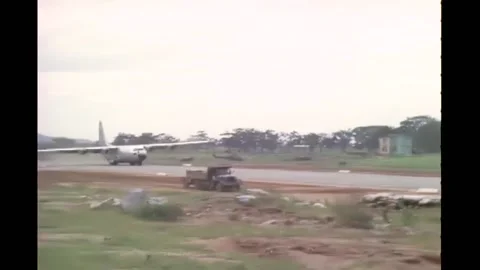 1965 - A C-130 plane lands at the An Khﾐ Army Airfield and a man directs loading Video stock 232892746
