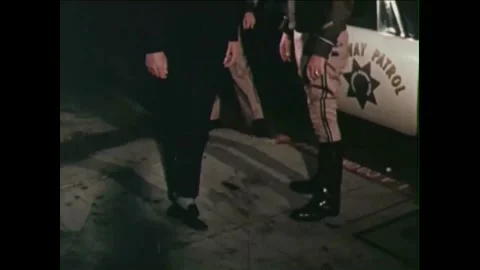 1965 - A man is pulled over at night for drunk driving, fails a sobriety test Stock Footage 155856485