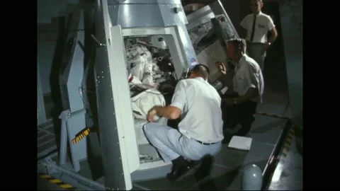 1965 - NASA technicians secure astronauts Frank Borman and Jim Lovell in a Stock Footage 232847878