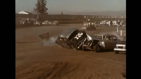 1966 Demolition Derby race in progress, two cars flip another car with license Stock Footage 234191862