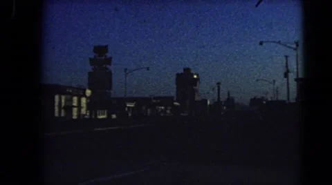 1966: driving down street in mid sized city during dusk BARSTOW, CALIFORNIA Stock Footage