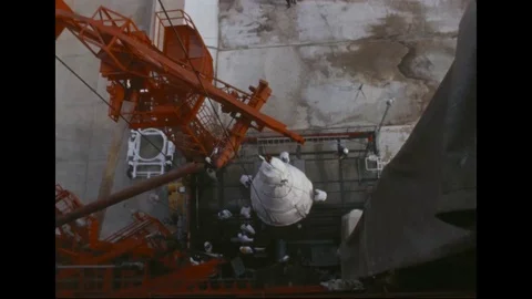 1966 - Engineers tighten a screw on the Gemini IX head as it is erected at the Vídeo Stock 115348911