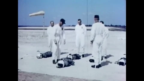 1966 - A man demonstrates how to put on a parachute pack. Stockbeeldmateriaal 83083428