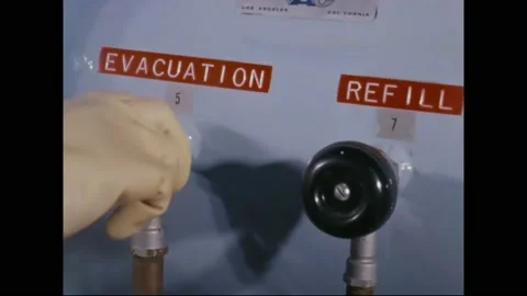 1966 - A NASA technician turns knobs labeled for evacuation and refill on a 스톡 동영상 232851316