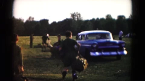 1966: several boys scouts in uniform carrying their bags to a parked car Stock Footage