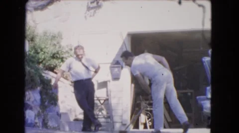 1966: two guys outside washing the driveway with a broom CATALINA, CALIFORNIA Stock Footage