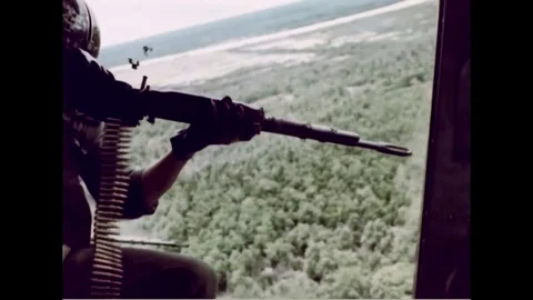 1966 Vietnam War - US Helicopter Gunner firing on vietcong positions Stock Footage
