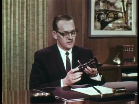 1967 _ A zoom lens is used as a scene is shot of a woman entering a mans office Stock Footage