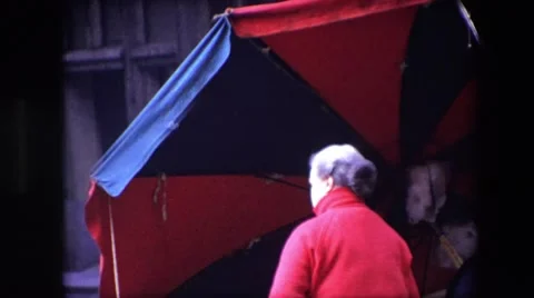 1967: A Grumpy Elderly Woman Struggles With Her Umbrella in Windy Brussels Stock Footage 68309022
