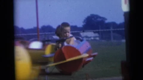 1967: little kids riding airplanes on an amusement park ride. CAMDEN, NEW JERSEY Stock Footage