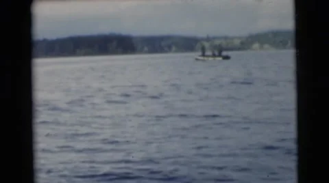 1967: men in a boat fishing across the lake as seen from another boat CAMDEN, Stock Footage