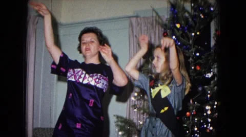 1967: mother and daughter doing hula dance in front of christmas tree NEVADA Stock Footage