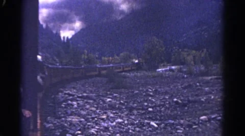 1967: the train makes it's was around the base of cold blue mountain. COLORADO Stock Footage