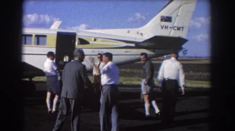 1967:BRISBANE AUSTRALIA.Group Of Men Stand Near White And Yellow Airplane On A Stock Photos