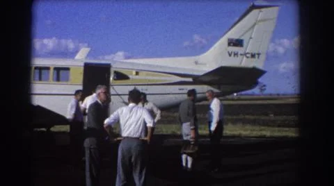 1967:BRISBANE AUSTRALIA.Group Of Men Stand Near White And Yellow Airplane On A Stock Photos