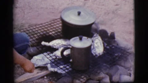 1968: camping out in the backyard while preparing food from a barbecue. Stock Footage
