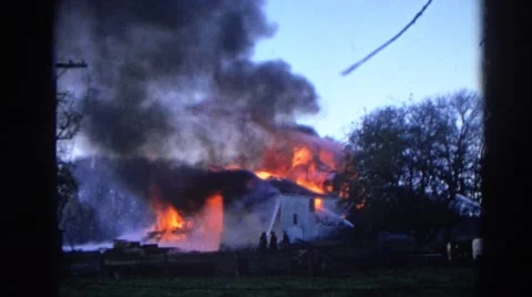 1968: firemen attempt to put out a large house fire with a water hose. WAUCONDA Stock Footage