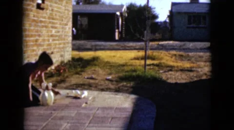 1968: group of boys setting up bowling pins to play outside in the summer Stock Footage