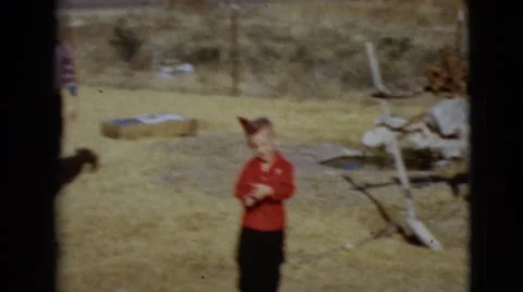 1968: a woman and boys outdoors running about with birthday hats CLARKSDALE Stock Footage