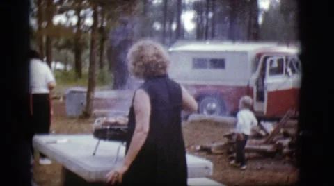 1968: a woman in the park cooking dinner on a portable grill COTTONWOOD, ARIZONA Stock Footage