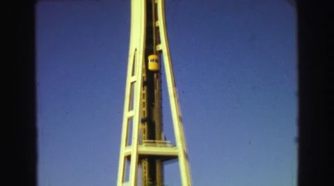 1968: A Yellow Exterior Elevator Climbing to the Top of the Seattle Space Needle Stock Footage 67739982
