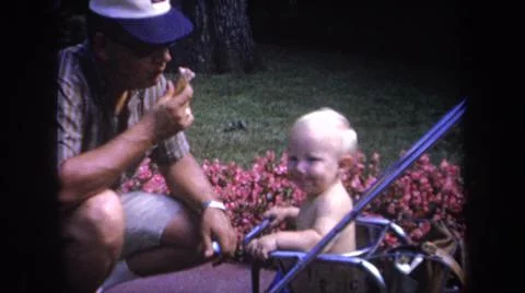 1968:MICHIGAN USA. Homem Brincando Com Uma Criança Muito Linda E Feliz Os Outros Stock Photos