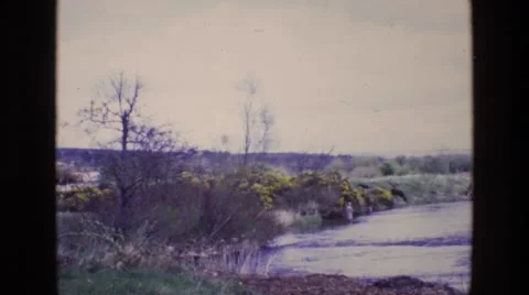 1969: a man standing in a beautiful river fly fishing ENGLAND Stock Footage