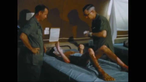 1969 - US Army medics apply cream to the burns of a Vietnamese POW in his care. 스톡 동영상 246046830