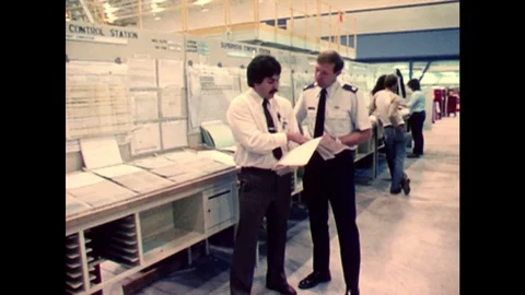 1970s: air force men look over plane build plans. Man walks around plane in Stock Footage