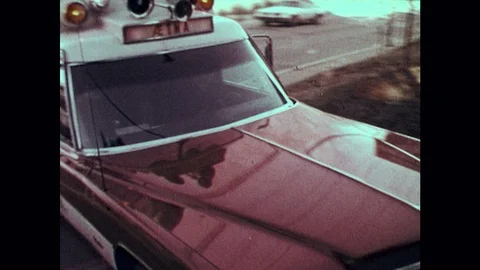 1970s: Ambulance drives. Woman pushes man on stretcher in hospital. Woman Stock Footage 121384227