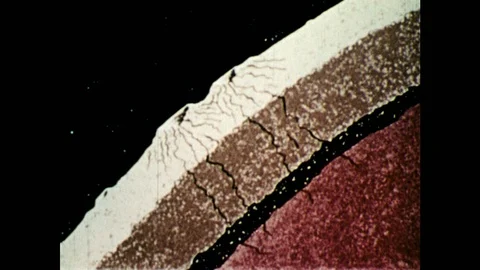 1970s: Animation of objects hitting moon.  Cross-section of moon shows cracks.  Stock Footage 86808965