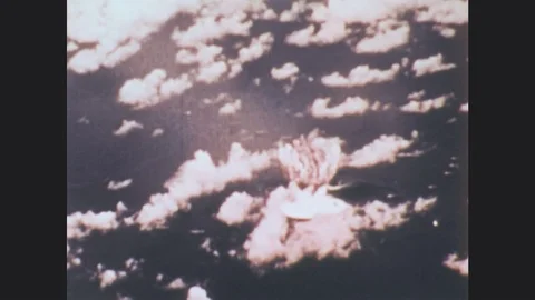 1970s: atomic bomb explodes mushroom cloud at bikini atoll. factory smokestacks Stock Footage
