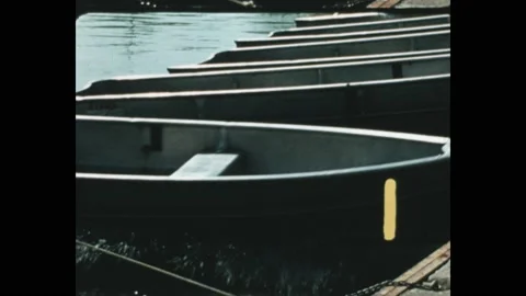 1970s: Boats pulled off the dock into the water, numbers count them as they go. Stock Footage 189940219