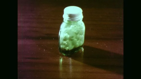1970s: Bottle of pills on table. Bottles of pills on table. Kaleidoscope image Stock Footage 102002459