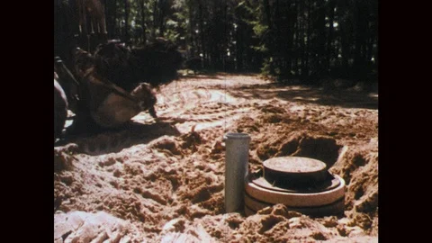 1970s: Bulldozer moves earth near septic tank construction site. Trench in dirt Stock Footage